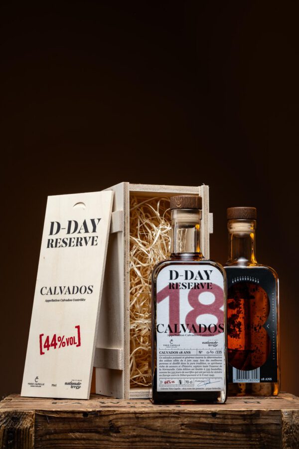 Bouteilles de Calvados D-Day Réserve 18 ans dans un coffret en bois, étiquettes détaillant l'appellation et le taux d'alcool.