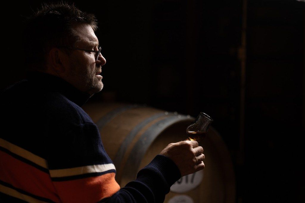 Un œnologue du cidre qui fait tournoyer son verre