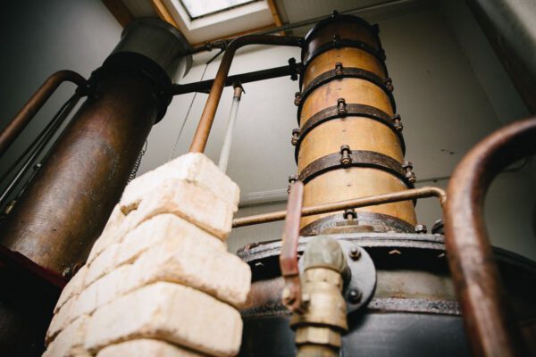 Distillation d'alcools dans la cidrerie Théo Capelle, mettant en valeur un équipement artisanal au cœur du Cotentin.