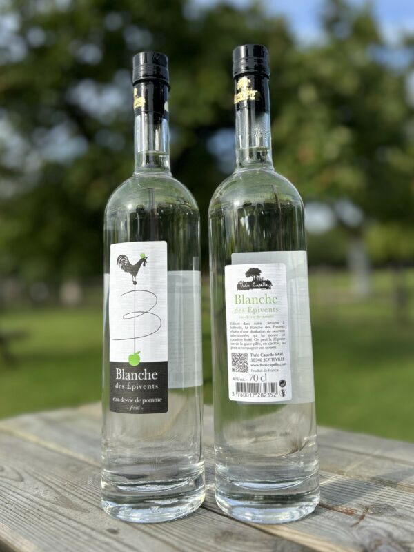 Bouteilles de Blanche des Épivents, eau-de-vie de pomme, 70 cl, sur une table en bois avec un fond naturel.