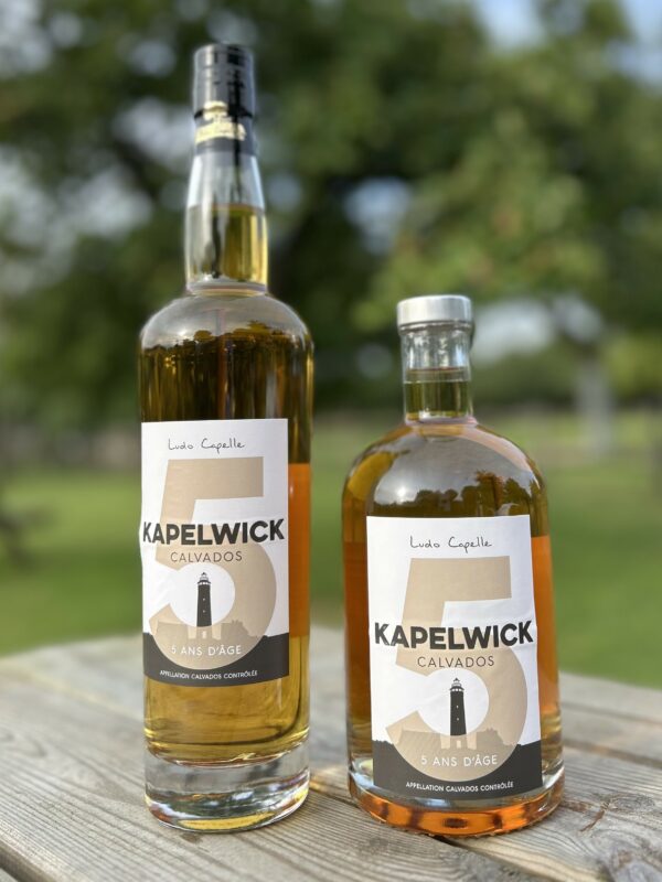 Bouteilles de Calvados AOC Kapelwick 5 ans d'âge de la cidrerie Théo Capelle, sur un fond naturel.