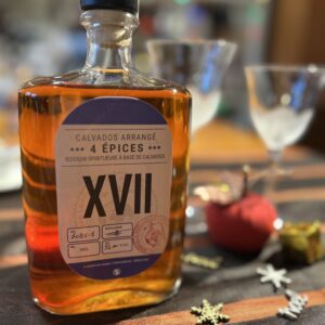 Bouteille de Calvados arrangé 4 épices, distillerie Théo Capelle, sur une table décorée.